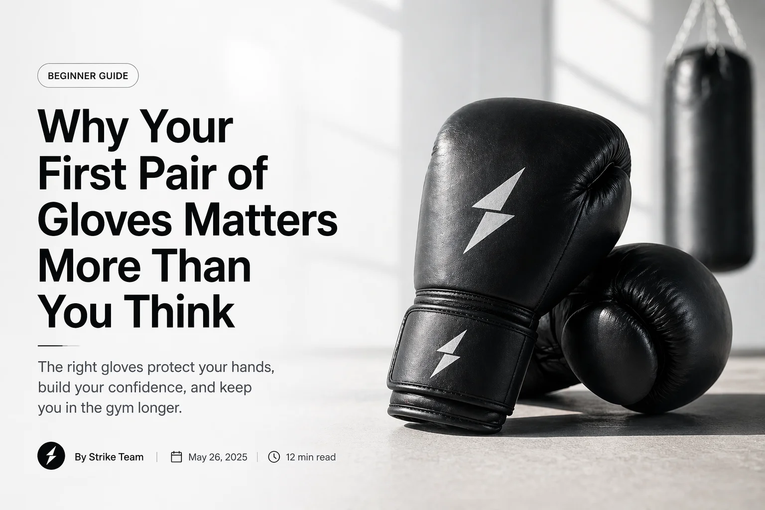 Black leather boxing gloves for beginners placed on gym floor with punching bag in background